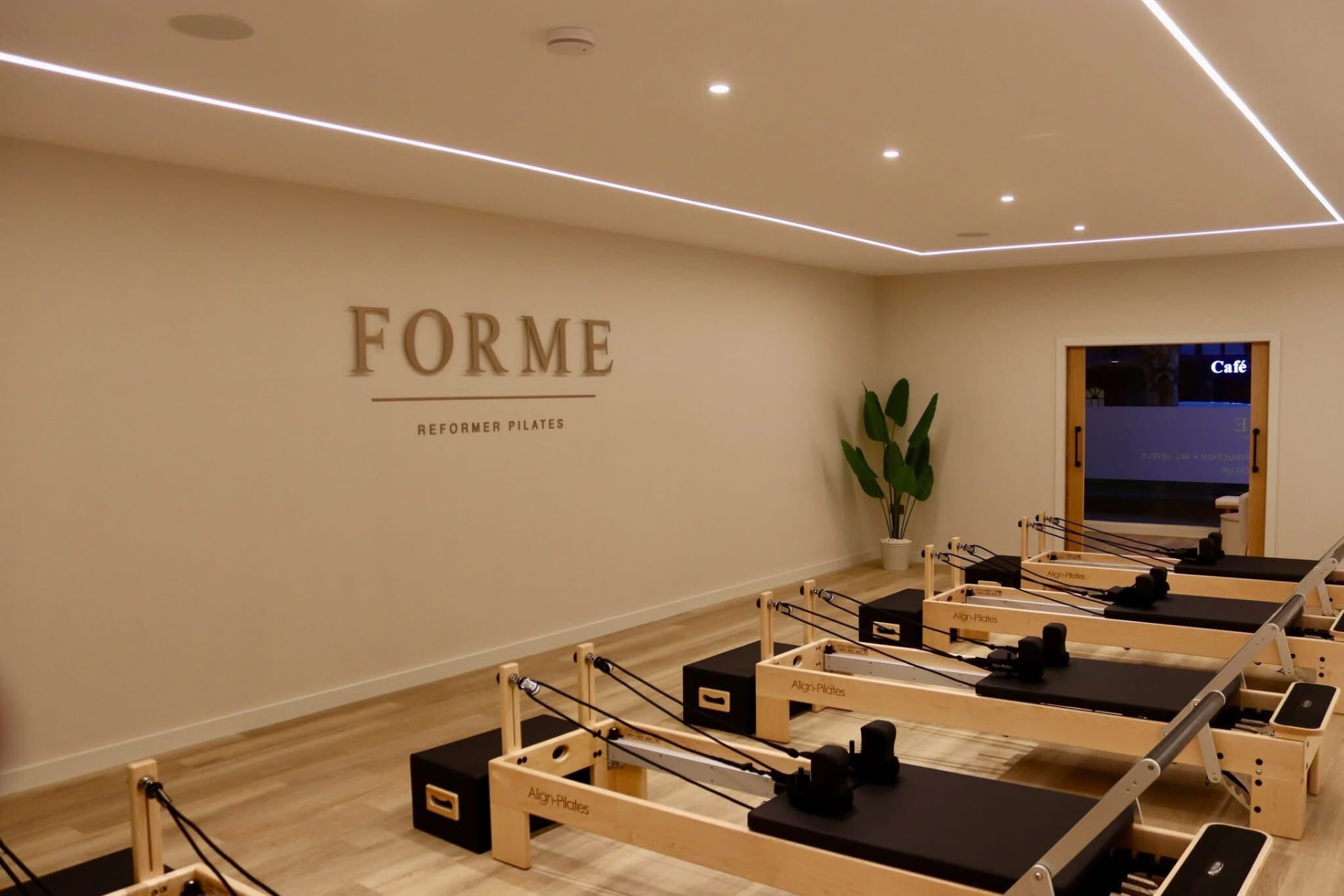 The FORME wall lettering above the five reformers in the studio
